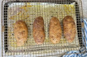four seasoned baked potatoes without foil on a wire rack lined baking sheet.