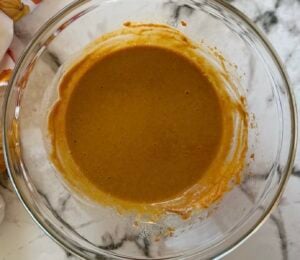 filling mixture for pumpkin pie tarts in a glass bowl.